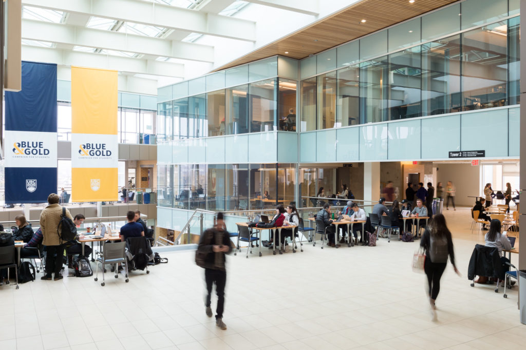 kelowna's university UBCO campus tower 2 interior, showing students walking to and from classes and others sitting at desks studying