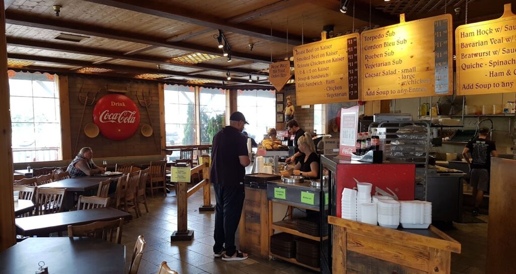 Interior view of Woodfire Bakery in Kelowna, showing the ordering counter and menu's, with tables for eating –  photo by Melvin Lau for Google Reviews